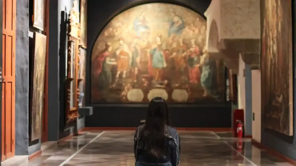 Mujer viendo una pintura en un museo de Puebla.